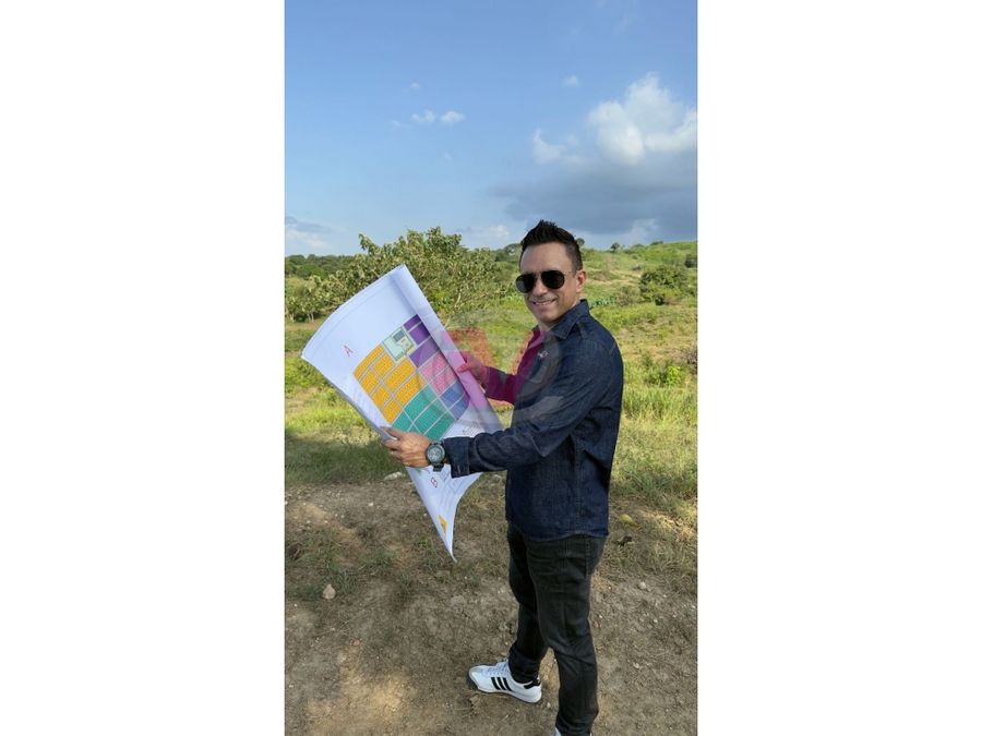 Néstor Andrade como agente inmobiliario con plano del proyecto en mano